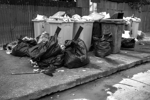 Construction site with waste materials being cleared by professionals in Queens Park